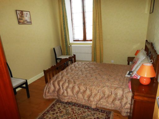 Chambre 1 Chambre simple avec un lit, des chaises et une fenêtre illuminant l’espace.